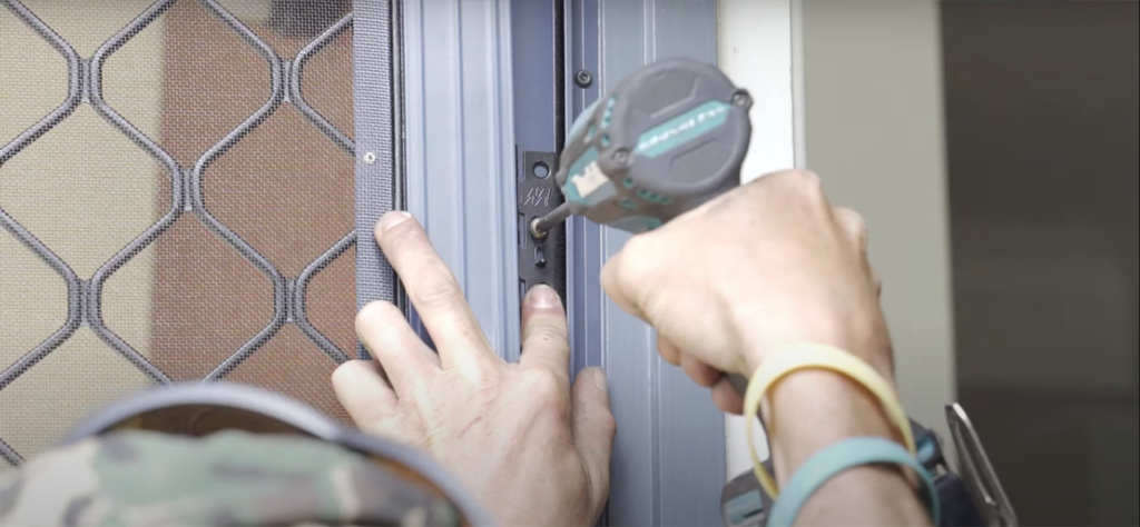 Worker installing security door Worker installing security door