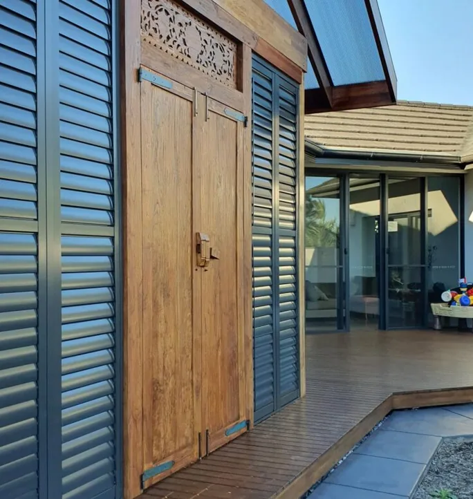 Aluminium shutters beside a timber entry door