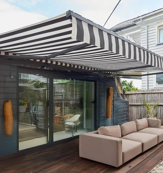 Striped crank awning over sliding doors