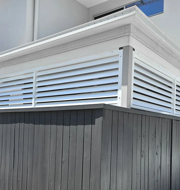 White fixed blade louvres above a timber wall