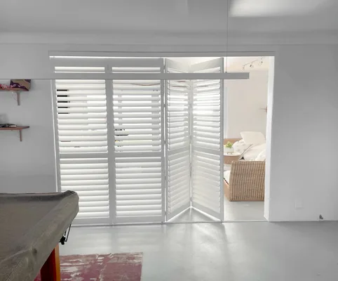 Plantation shutters on sliding doors in a games room