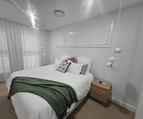 Sheer curtains and shutters in a bedroom