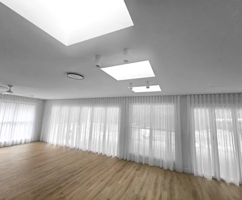 Sheer curtains around a skylit living room