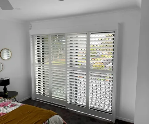 Plantation shutters on sliding doors in a bedroom