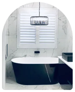 White plantation shutters in a bathroom with a freestanding bath