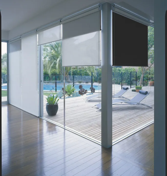Roller blinds on floor-to-ceiling windows by a pool