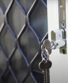 Diamond grille security door with key in the lock