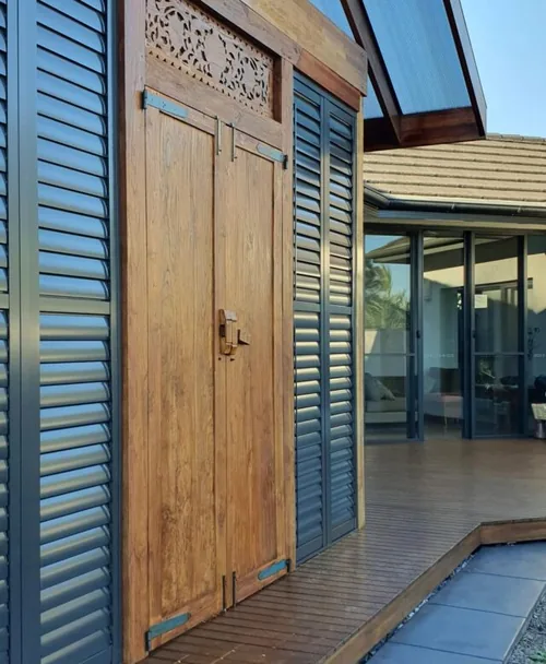 Aluminium shutters beside a timber entry door