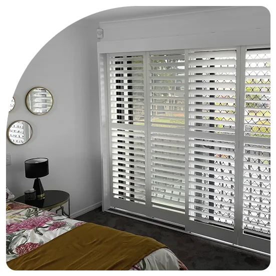 Plantation shutters on sliding doors in a bedroom