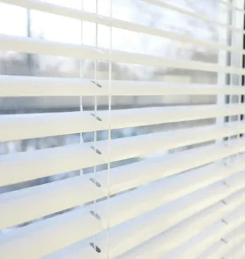 White Venetian blind slats with light coming through